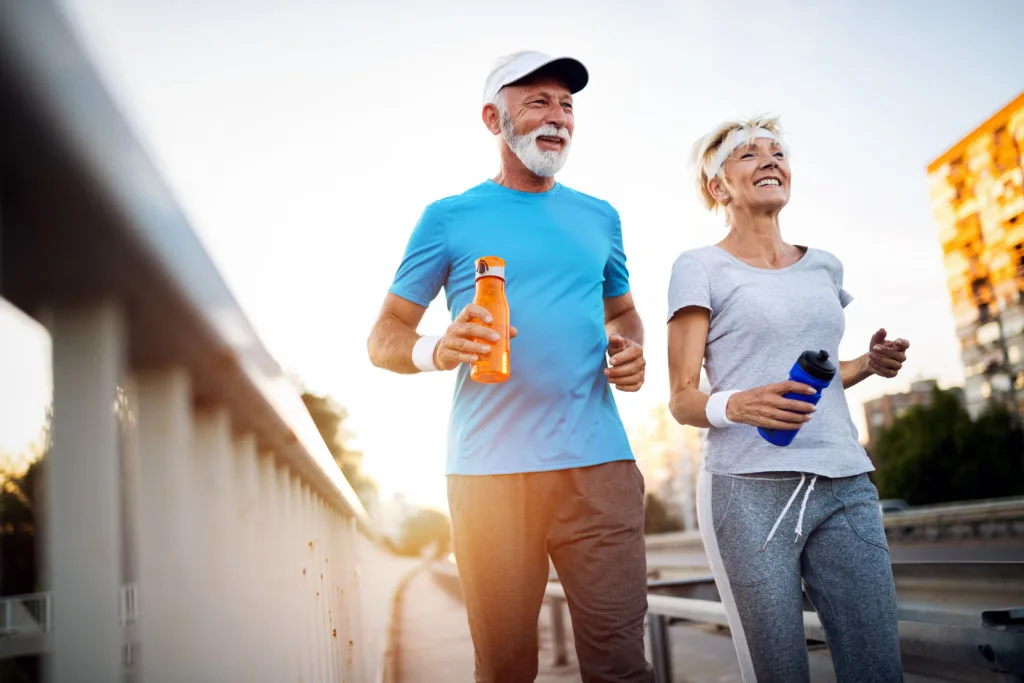 Older Couple Running with hearing aid fitness trackers