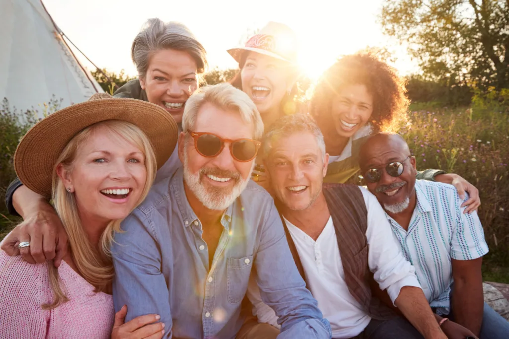 group of friends with the sun behind them enjoying life and staring at the camera.